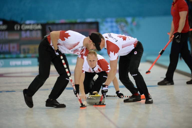 Canada's Brad Jacobs (C) watches his stone during the 2014 Sochi winter olympics men's curling. ©AFP