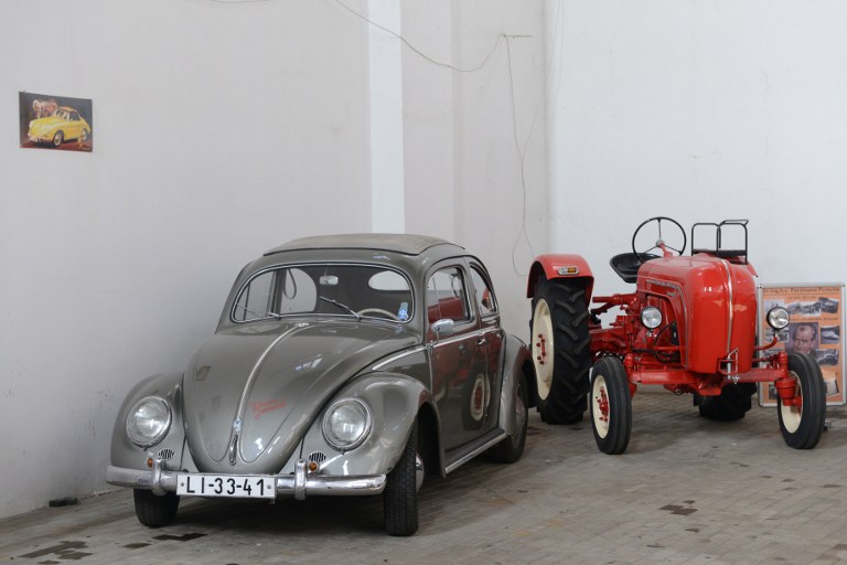 A Volkswagen Beetle (L) and a Porsche tractor are displayed in a hall of car collector Milan Bumba in Vratislavice village