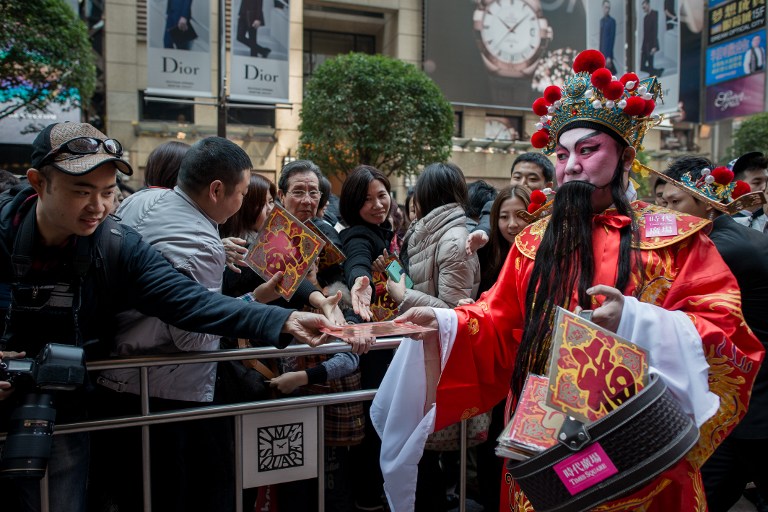 A performer wearing a traditional costume distribute cards symbolising envelopes called 