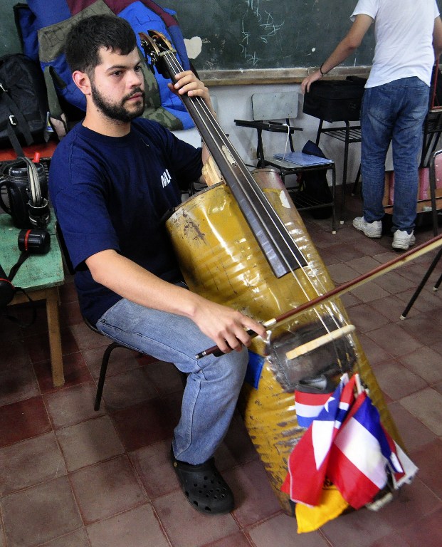 A musician from a Paraguayan juvenile symphonic orchestra shows his cello made out of recycled trash during a rehearsal in Asuncion. ©AFP