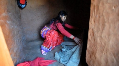 Chandrakal Nepali prepares her bedding inside a 
