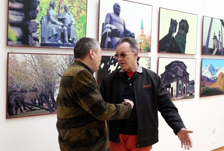 Actor Gennadiy Balayev talks to one of the visitors of the exhibition.