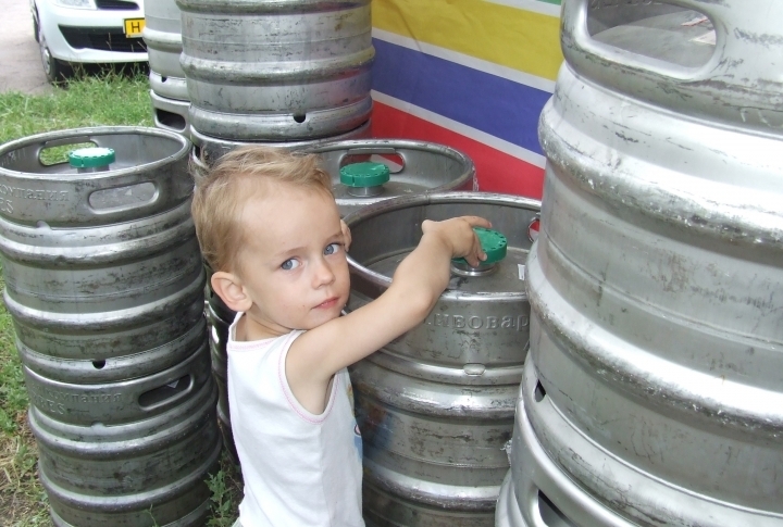 A kid trying to find beer in barrels. ©Roza Yessenkulova 
