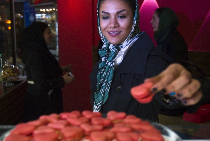 An Iranian woman takes a Valentines Day cookie at a pastry shop in Tehran. ©REUTERS/Raheb Homavandi
