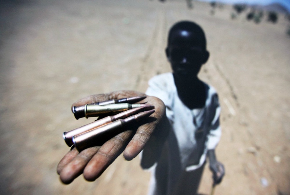 A kid holding bullets collected from the ground in Northern Darfur's village. March 27, 2011<br> UN Photo/Albert Gonzalez Farran©