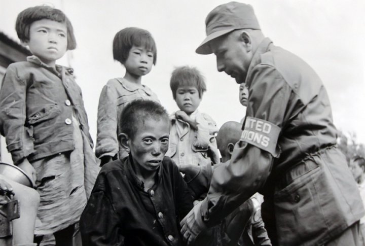 Orphans found wondering in the ruins of Seoul are taken to an orphanage by UN officer. <br>UN Photo/GM©