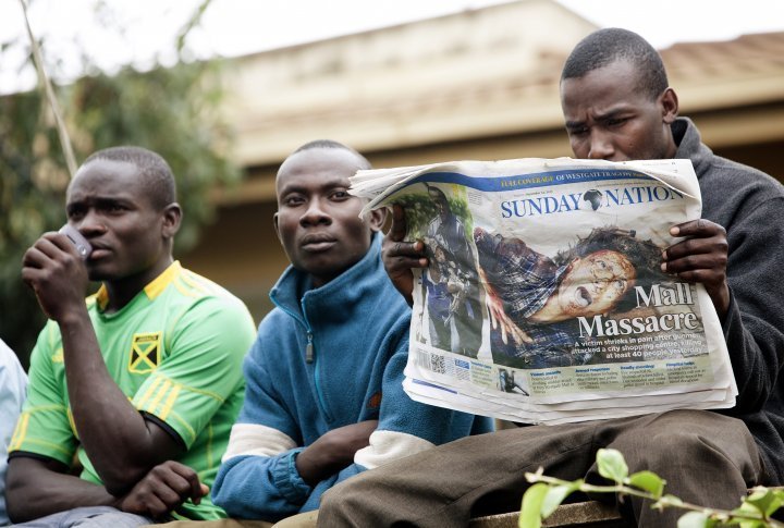 A men reading a daily at the fringe of the Westgate perimeter the day after the attack. ©REUTERS