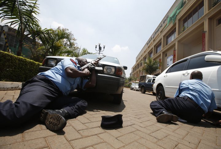 Police sheltering behind cars near Westgate trade center in Nairobi, September 21, 2013. ©REUTERS