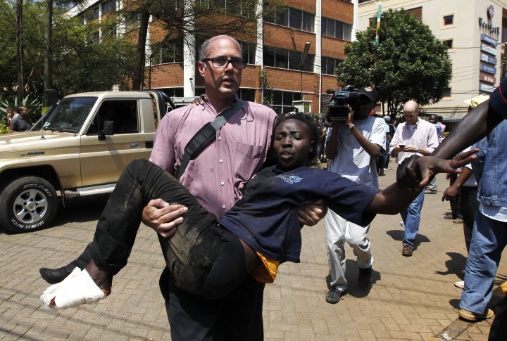 A journalist rescuing a wounded woman near the Westgate mall in Nairobi, September 21, 2013. ©REUTERS