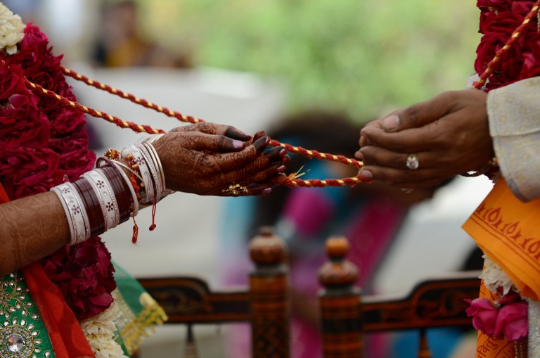 Bridal couple participate in Hindu rituals during a marriage.
