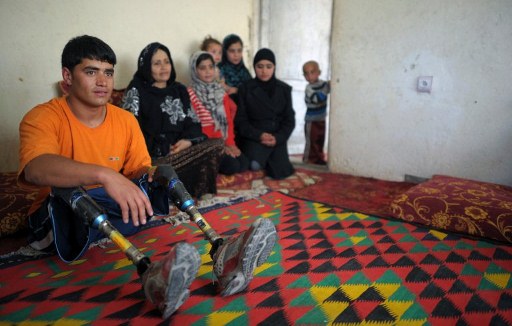 Afghan amputee Malek Mohammad (L) poses with his family at home in Kabul. ©AFP 