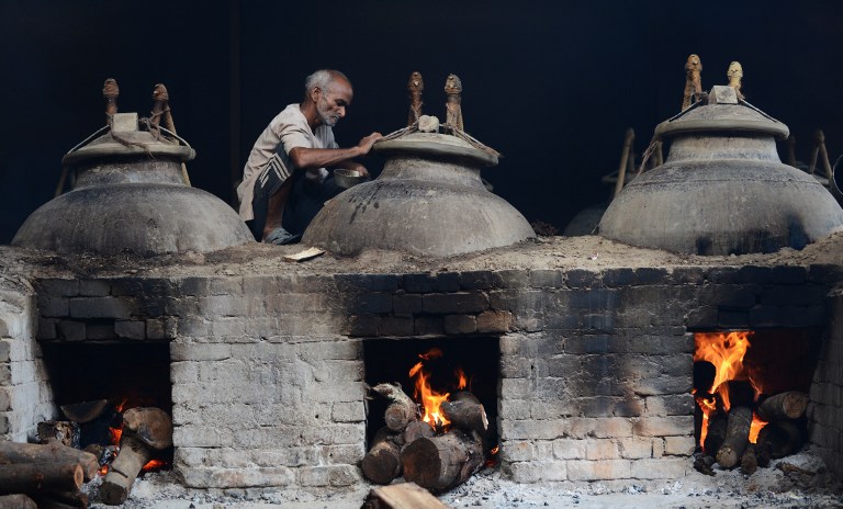 an Indian perfume producer boils Attar, purfume, at a factory. ©AFP