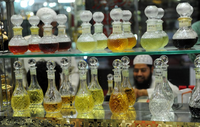 An Indian Muslim tests Attar, perfume, before purchasing it at a shop. ©AFP