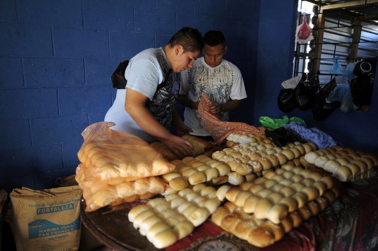 Members of the 18th street gang put bread into bags at a bakery. ©AFP