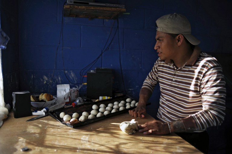 A member of the 18th street gang prepares dough at a bakery. ©AFP