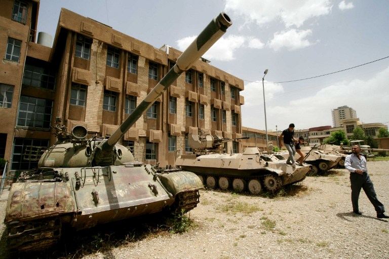 Iraqi Kurds look at tanks as they visit a former torture centre that was turned into a museum. ©AFP