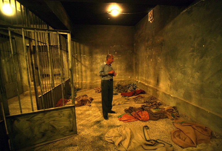 An Iraqi Kurd visitor stands in a cell at a former torture centre. ©AFP