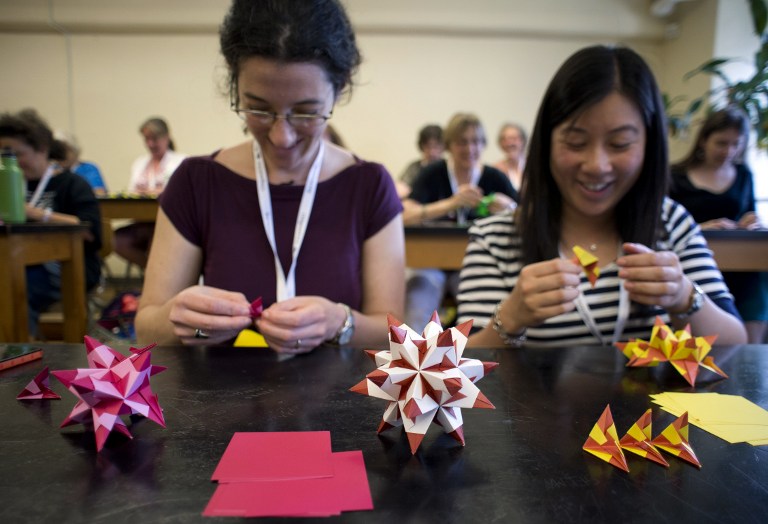 Two young women make Bascetta Stars during an Origami class at the Origami Convention. ©AFP