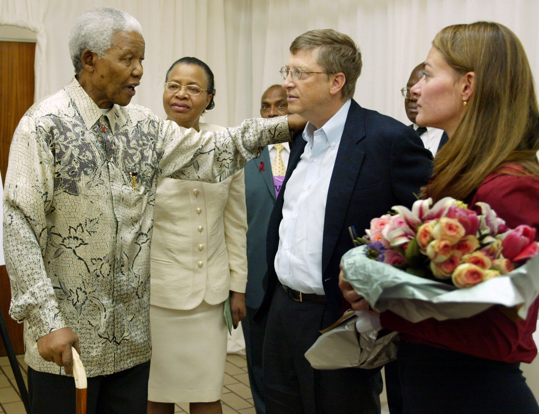 Former South African President Nelson Mandela (L) and his wife Graca Machel talk to Bill and Melinda Gates (R) at the end of a youth forum on HIV/AIDS at the University of Witwatersrand in Johannesburg, South Africa September 22, 2003. 