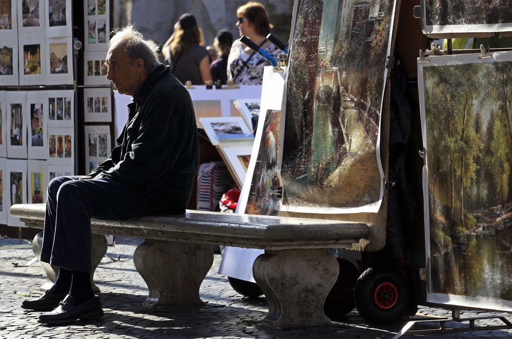 A man sits on a bench at Navona Square in Rome November 10, 2011. ©REUTERS/Stefano Rellandini