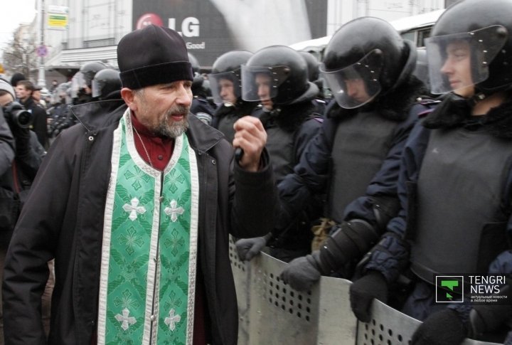 A Priest calls the police to protect their people. ©Vladimir Prokopenko
