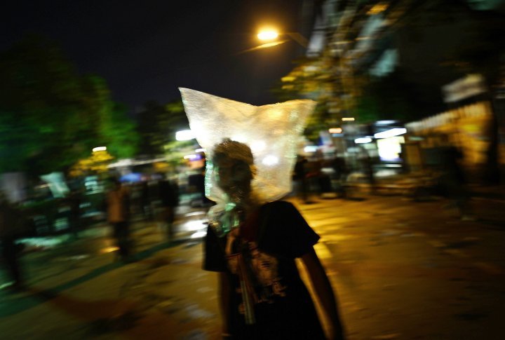 A demonstrator uses a plastic bag to protect himself from tear gas. ©Reuters