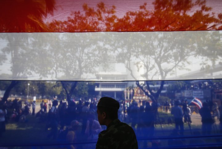 A soldier stands in fromt of Thai national flag. ©Reuters