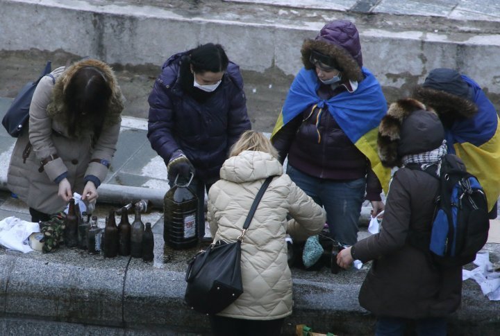 Women filling bottles with flamable liquid. ©Reuters