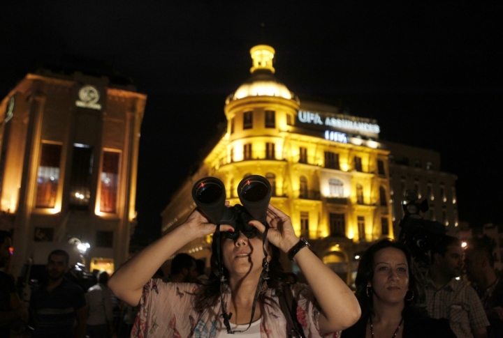 A woman with binocular watching lunar eclipse in Beirut, Lebanon. ©REUTERS/Jamal Saidi