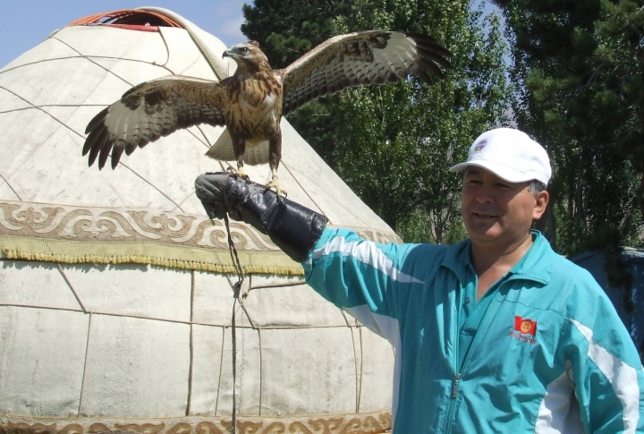 Eagle master offering to take a photo with the bird for small money. ©Roza Yesenkulova 
