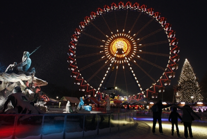 People skate at an ice rink near a ferris wheel at a Christmas market in central Berlin, Germany. ©REUTERS\Thomas Peter