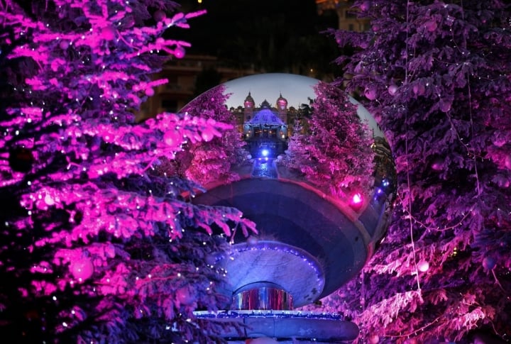 Monte Carlo casino is reflected in a mirror between Christmas trees in Monaco. ©REUTERS\Eric Gaillard