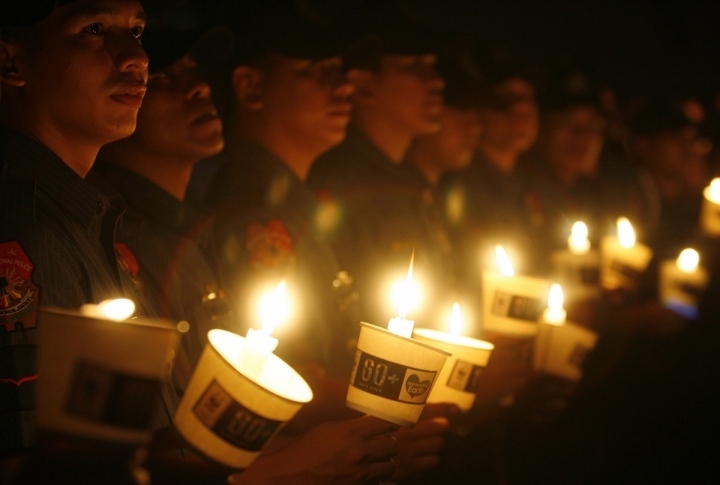 Philippine police hold candles as they join the celebration of Earth Hour in Manila's Makati financial district. ©REUTERS/Cheryl Ravelo