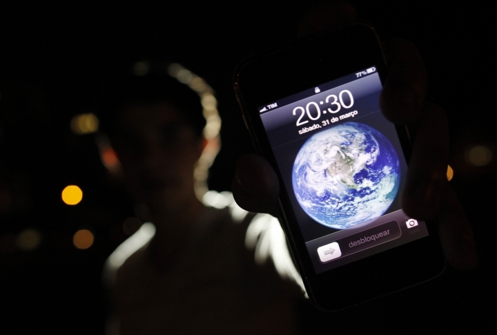 A man poses with an iPhone during Earth Hour in the center of Brasilia, Brazil. ©REUTERS/Ueslei Marcelino