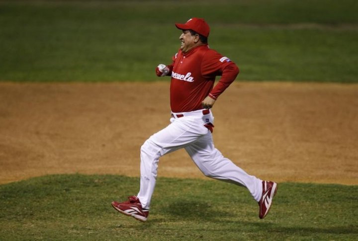 Venezuelan President Hugo Chavez runs between second and third base during a friendly softball game. ©REUTERS/Jorge Silva