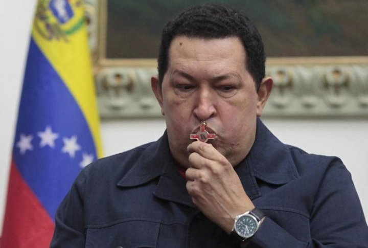 Venezuelan President Hugo Chavez kisses a crucifix as he speaks during a national broadcast at Miraflores Palace in Caracas. ©REUTERS/Miraflores Palace/Handout