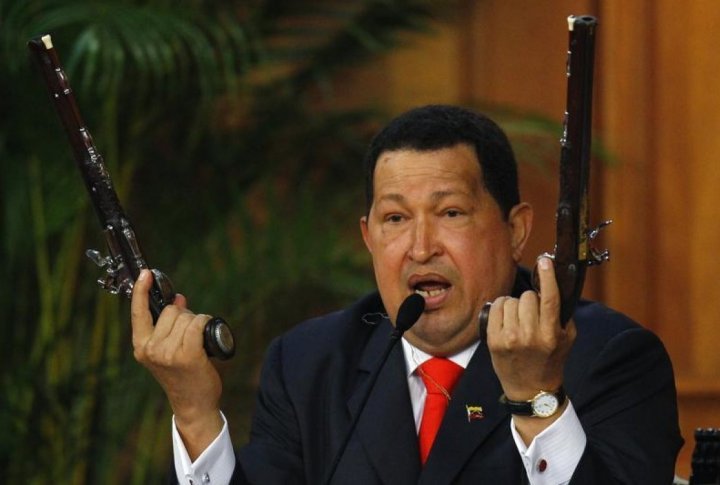Venezuelan President Hugo Chavez shows the pistols of independence hero Simon Bolivar during a ceremony to mark his birthday in Caracas. ©REUTERS/Carlos Garcia Rawlins
