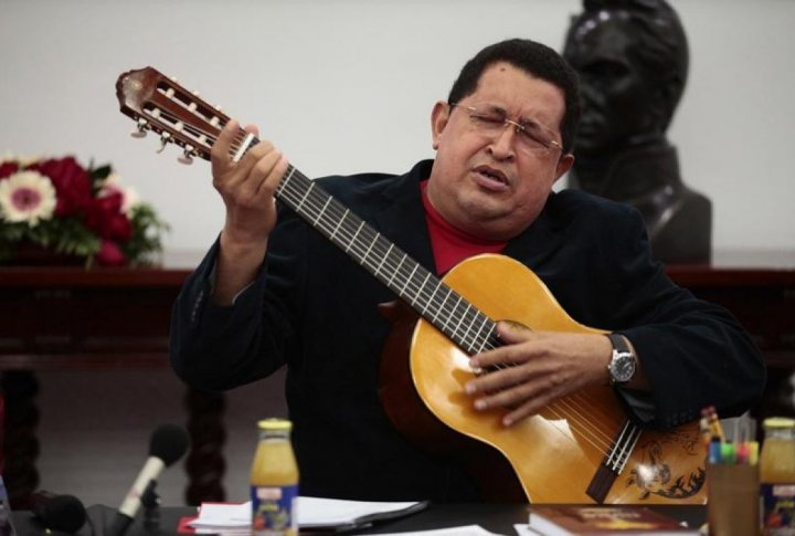 Venezuelan President Hugo Chavez plays a guitar, which was a gift from Mexican singer Vicente Fernandez, during a cabinet meeting at Miraflores Palace in Caracas. ©REUTERS/Miraflores Palace