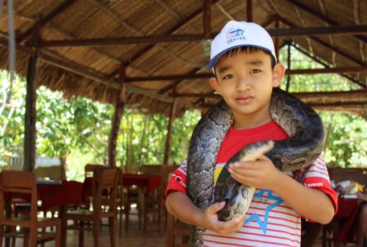 A boy with a python. Photo by Roza Yessenkulova©