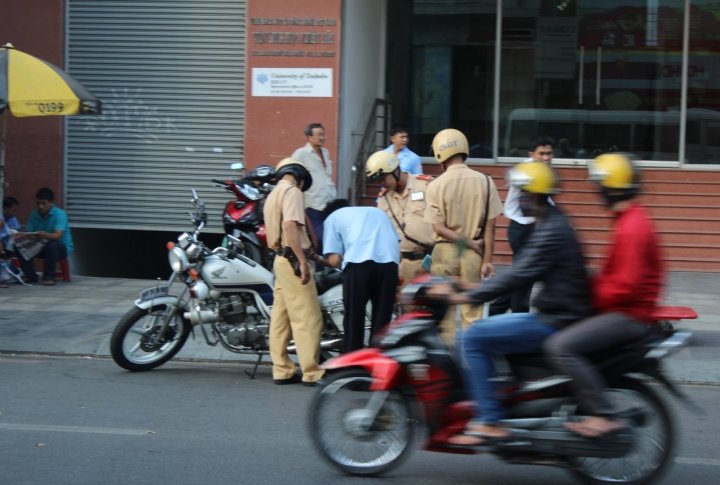 Ho Chi Minh road police checking a biker's documents. Photo by Roza Yessenkulova©