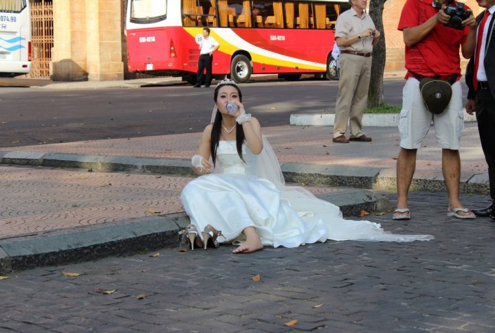 A tired bride next to Main Post office in Ho Chi Minh City. Photo by Roza Yessenkulova©