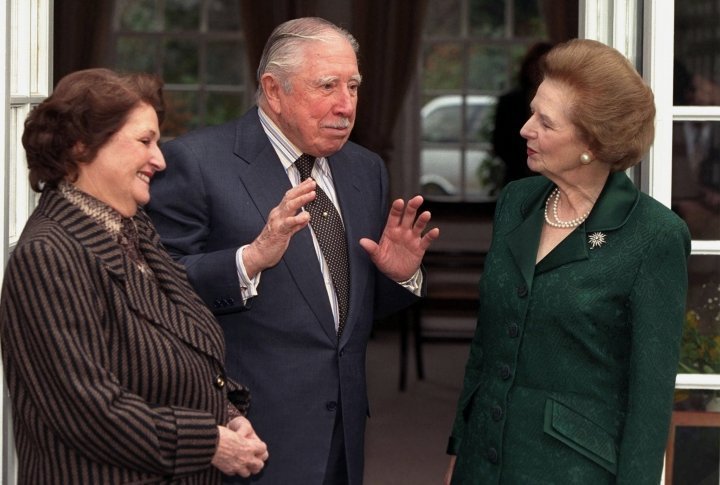 Former British Prime Minister Margaret Thatcher (R) is greeted by former Chilean dictator General Augusto Pinochet and his wife Lucia at the house in Wentworth where he remains under house arrest, March 26, 1999. ©REUTERS