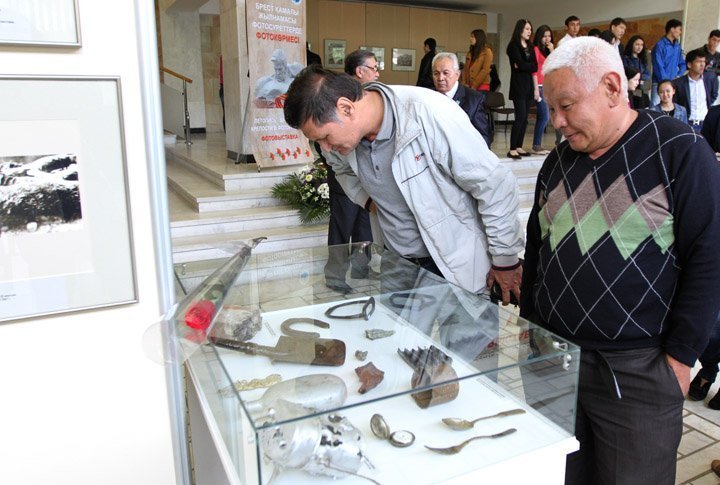 Visitors of the exhibition checking on the WWII military items.