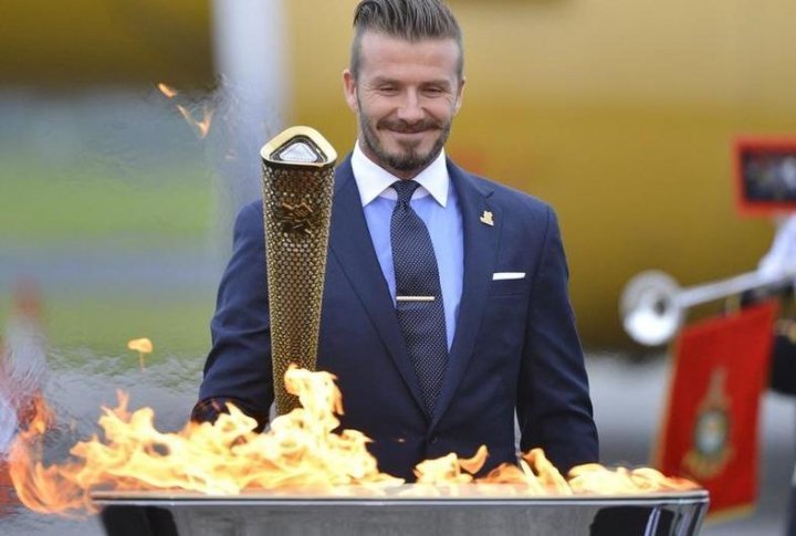 British soccer player and London 2012 Olympic Games ambassador David Beckham reacts after lighting the Olympic torch. ©REUTERS/Toby Melville