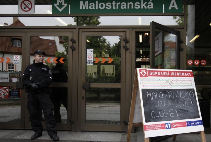 A police officer stands guard in front of a closed subway station in Prague. ©REUTERS