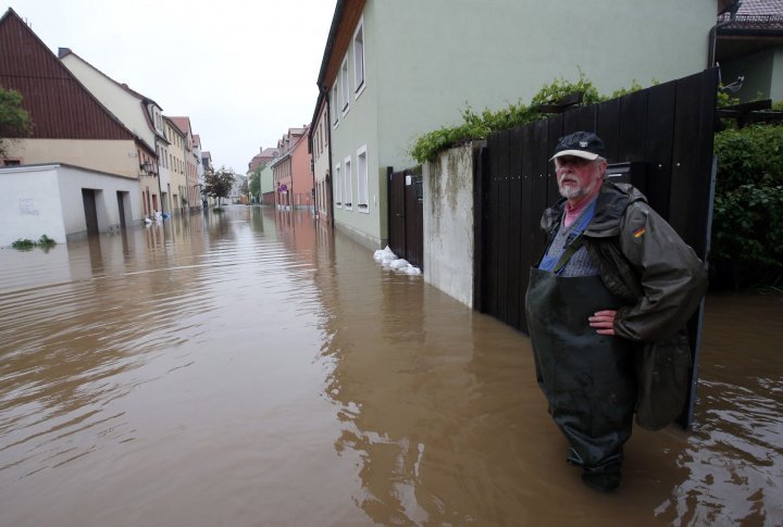 A resident stands at his property on a flooded street in the town of Grimma, near Leipzig. ©REUTERS