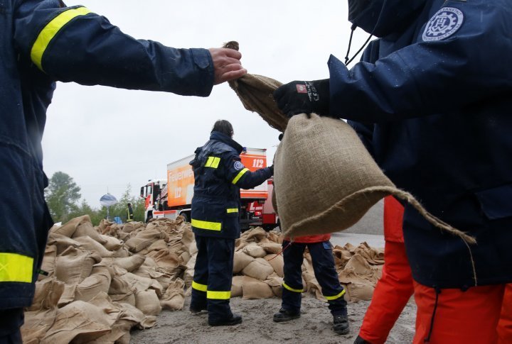 Members of the Federal Agency of Technical Relief (THW) load sandbags in Hirschfeld near Leipzig. ©REUTERS
