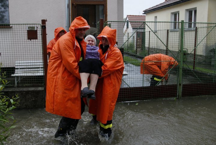 Firefighters evacuate a lady from her flooded house in the south Bohemian village of Nemcicky. ©REUTERS