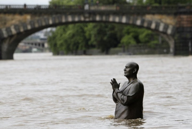 The statue of world harmony leader Sri Chinmoy is partially submerged in water from the rising Vltava river in Prague. ©REUTERS