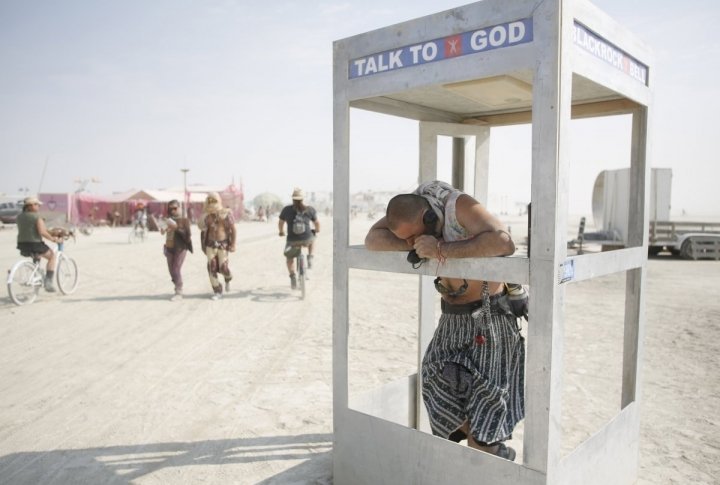 Pippin, his Playa name, chats on the phone with God during the Burning Man 2013 arts and music festival. ©REUTERS